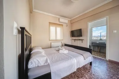 a bedroom with a bed with a television and a window at Acropolis View - Cozy Studio 4 Metro Neos Kosmos in Athens