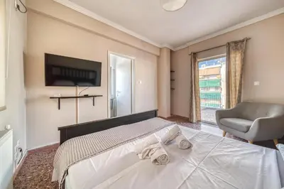 a bedroom with a bed and a chair and a television at Acropolis View - Cozy Studio 4 Metro Neos Kosmos in Athens