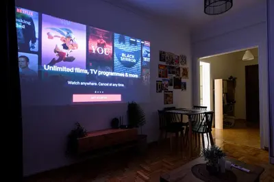 a living room with a large screen on a wall at Patision cinema apartment in Athens