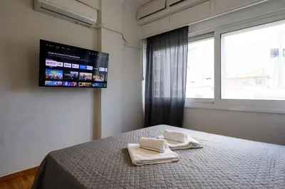 a bedroom with two towels on a bed with a tv at Patision cinema apartment in Athens