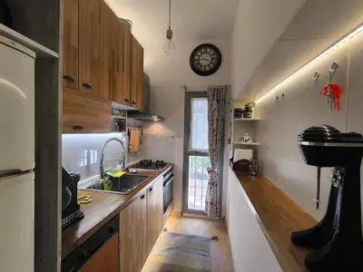 a kitchen with a sink and a clock on the wall at Silver Paradeisi Apartment in Palaiá Fókaia