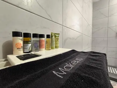 a shelf with five bottles of hair products on it at Silver Paradeisi Apartment in Palaiá Fókaia