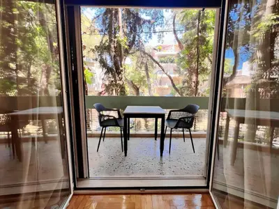 a table and chairs in front of a large window at Dafni 2Bdrm apartment in Neapoli by ΜΡS in Athens