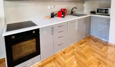a kitchen with white cabinets and a black oven at Dafni 2Bdrm apartment in Neapoli by ΜΡS in Athens