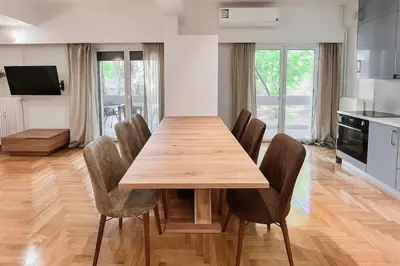 a dining room with a wooden table and chairs at Dafni 2Bdrm apartment in Neapoli by ΜΡS in Athens
