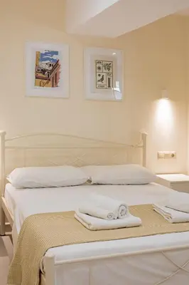 a white bedroom with two beds with towels on them at Kynos Athens Studio in Athens