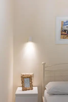 a clock sitting on a nightstand next to a bed at Kynos Athens Studio in Athens