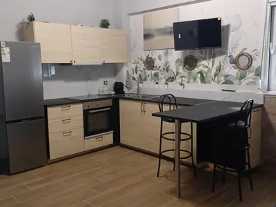 a kitchen with a refrigerator and a table with chairs at Family station in Athens