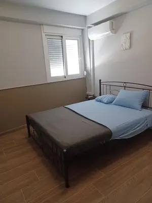 a bedroom with a bed in a room with two windows at Family station in Athens