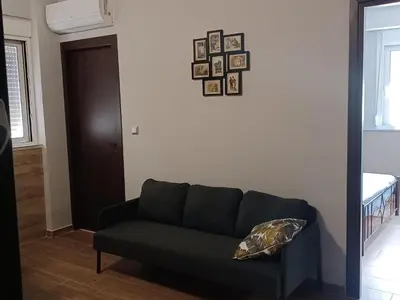 a living room with a couch and pictures on the wall at Family station in Athens