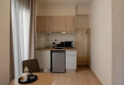 a small kitchen with a table and a microwave at Nuvia UrbanStay Piraeus Apartments in Piraeus