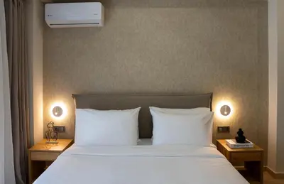 a bedroom with a bed with white sheets and pillows at Nuvia UrbanStay Piraeus Apartments in Piraeus