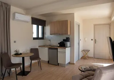 a kitchen and living room with a table and chairs at Nuvia UrbanStay Piraeus Apartments in Piraeus