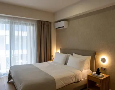 a hotel room with a bed and a large window at Nuvia UrbanStay Piraeus Apartments in Piraeus
