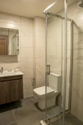 a bathroom with a toilet and a sink and a shower at Nuvia UrbanStay Piraeus Apartments in Piraeus