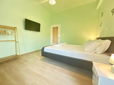 a bedroom with a bed with a television on the wall at Paloma Lux Retreat-15' to Central Athens in Athens