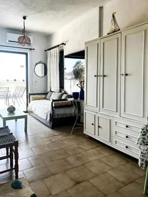 a bedroom with a bed and a large white cabinet at Αριάδνη στούντιο με θέα in Anavissos