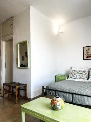 a bedroom with a bed and a table and a mirror at Αριάδνη στούντιο με θέα in Anavissos