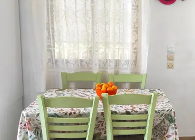 a table with two chairs and a bowl of oranges on it at Αριάδνη στούντιο με θέα in Anavissos