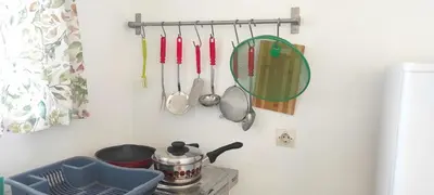 a kitchen counter with utensils hanging on a wall at Αριάδνη στούντιο με θέα in Anavissos