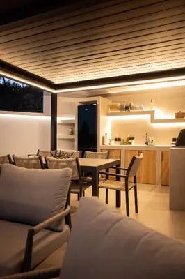 a living room with a table and chairs and a kitchen at Nicolas Villa in Anavissos