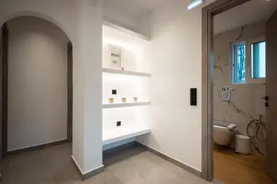 a bathroom with a white wall with a shelf at Nicolas Villa in Anavissos