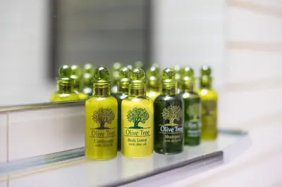 a row of bottles of olive oil on a shelf at Veni Acropolis Museum 2Bd Apt in Athens