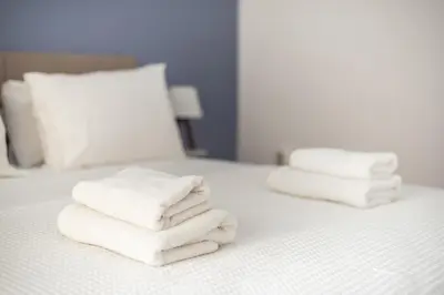 a pile of towels sitting on top of a bed at Veni Acropolis Museum 2Bd Apt in Athens