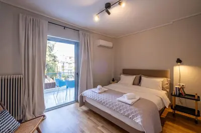a bedroom with a bed and a large window at Stylish 2BR with Balcony, Northern Suburbs in Athens