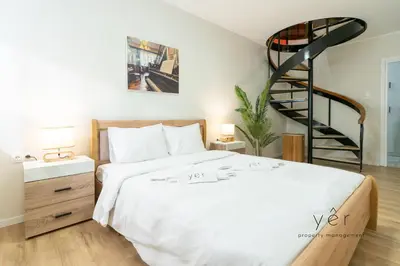 a bedroom with a bed and a spiral staircase at Duplex in Piraeus' Best Street 2Bath w-FreeParking in Piraeus