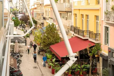 a group of people walking down a street with buildings at Duplex in Piraeus' Best Street 2Bath w-FreeParking in Piraeus