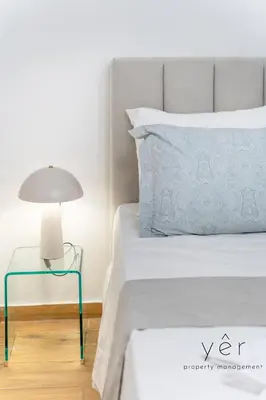 a bedroom with a bed and a lamp on a table at Seaside Loft Near Piraeus Port at Freatida Beach in Piraeus
