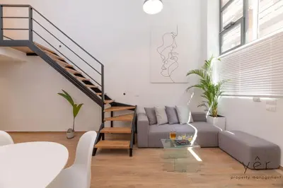 a living room with a couch and a staircase at Seaside Loft Near Piraeus Port at Freatida Beach in Piraeus