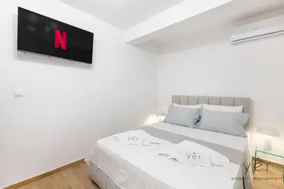 a bedroom with a bed with a tv on the wall at Seaside Loft Near Piraeus Port at Freatida Beach in Piraeus