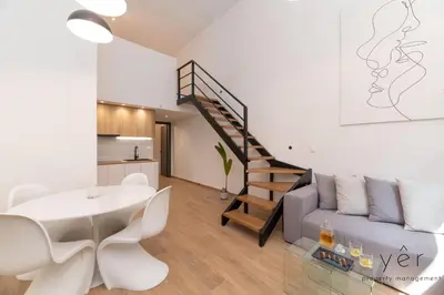 a living room with a couch and a staircase at Seaside Loft Near Piraeus Port at Freatida Beach in Piraeus