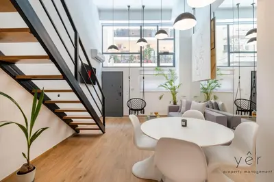 an office with a staircase and a table and chairs at Stylish Loft at Pasalimani 10min to Freatida Beach in Piraeus