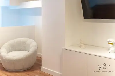 a white chair in a room with a tv at Stylish Loft at Pasalimani 10min to Freatida Beach in Piraeus
