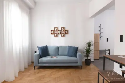 a living room with a blue couch and a table at Coastal Charm at Pasalimani - Steps from Port&Beach in Piraeus