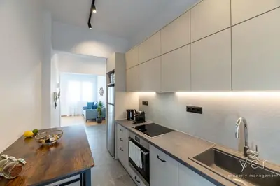 a kitchen with white cabinets and a wooden counter top at Coastal Charm at Pasalimani - Steps from Port&Beach in Piraeus