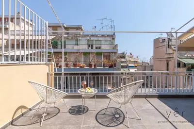 a balcony with two chairs and a table on a building at Coastal Charm at Pasalimani - Steps from Port&Beach in Piraeus