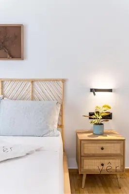a bedroom with a bed and a nightstand with a plant on it at Coastal Charm at Pasalimani - Steps from Port&Beach in Piraeus
