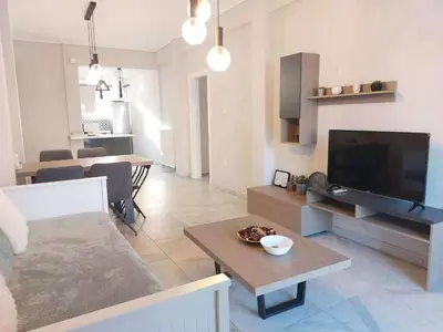 a living room with a television and a living room with a table at An's Luxury comfort home in Athens
