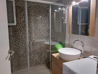 a bathroom with a shower with a sink and a tub at An's Luxury comfort home in Athens