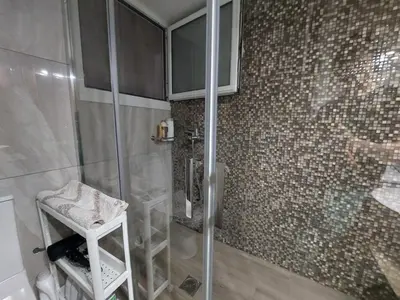 a shower with a glass door and a stool in a bathroom at An's Luxury comfort home in Athens