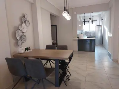 a kitchen and dining room with a wooden table and chairs at An's Luxury comfort home in Athens