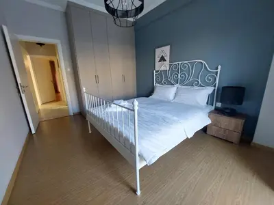 a bedroom with a white bed and a blue wall at An's Luxury comfort home in Athens