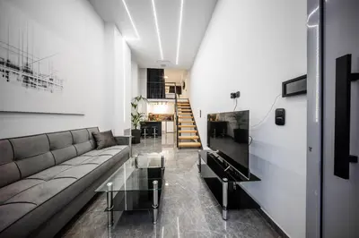 a living room with a couch and a glass table at Studio Noir in Athens