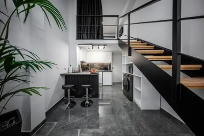 a kitchen with a staircase and a kitchen with stools at Studio Noir in Athens