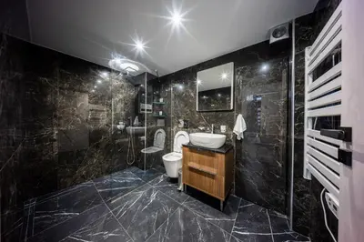 a black bathroom with a toilet and a sink at Studio Noir in Athens