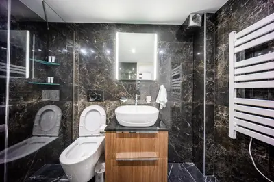 a bathroom with a sink and a toilet and a mirror at Studio Noir in Athens